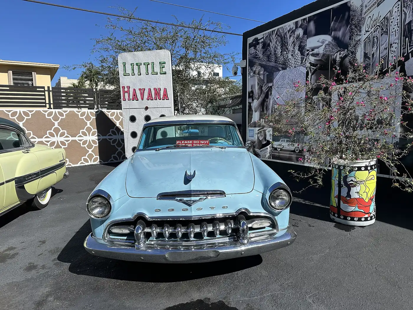 Classic cars parked by a Little Havana sign on Calle Ocho.