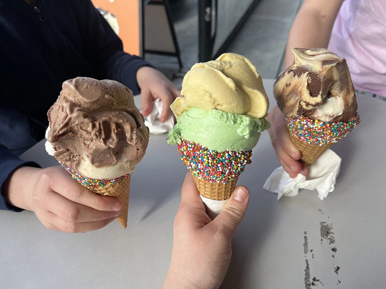 Three ice cream cones rolled in sprinkles. The photo was not taken at a Miami shop.