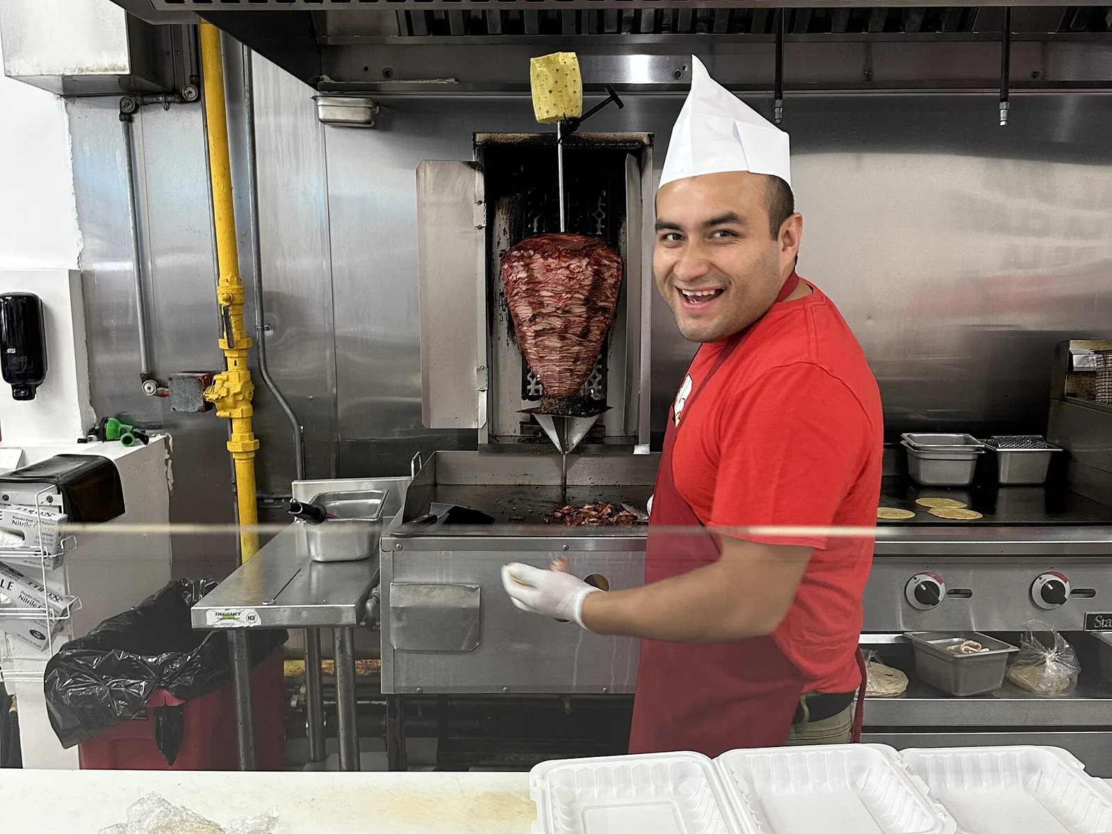 A cook beside the trompo at Tacos El Porky on West Flagler Street in downtown Miami, one of the places on this list.