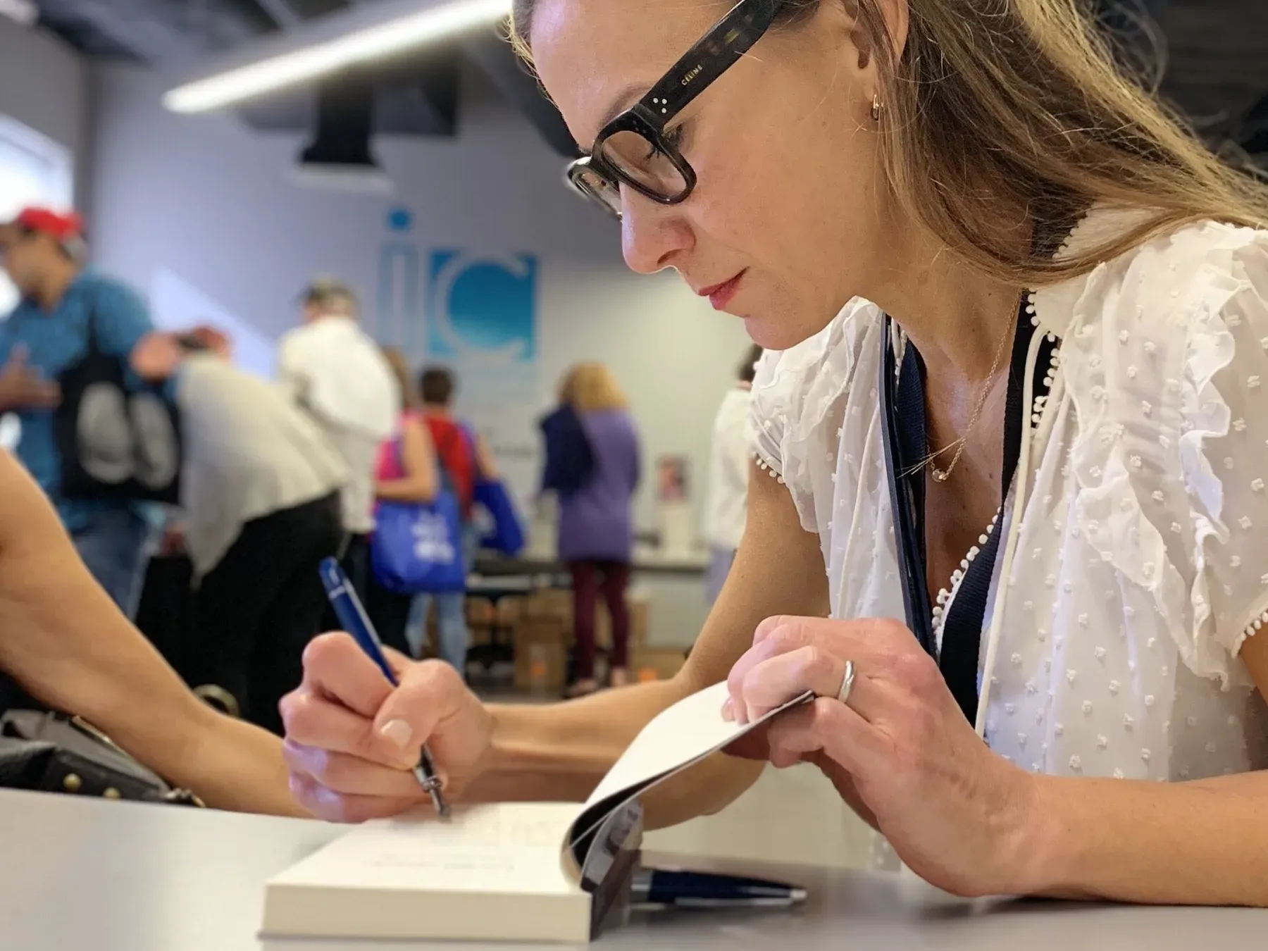 An author signs a copy of her book for a reader at Miami Book Fair.